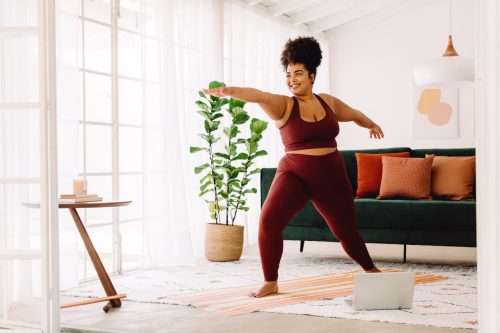 young woman doing yoga smiling