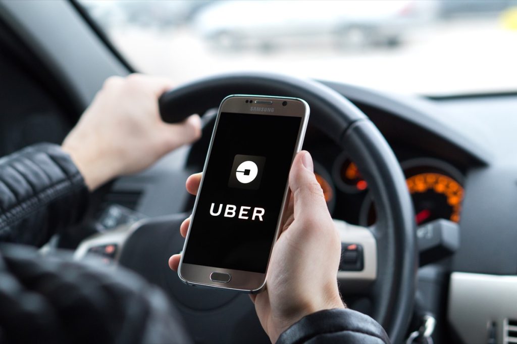 Người lái xe đang xem ứng dụng Uber trên điện thoại thông minh