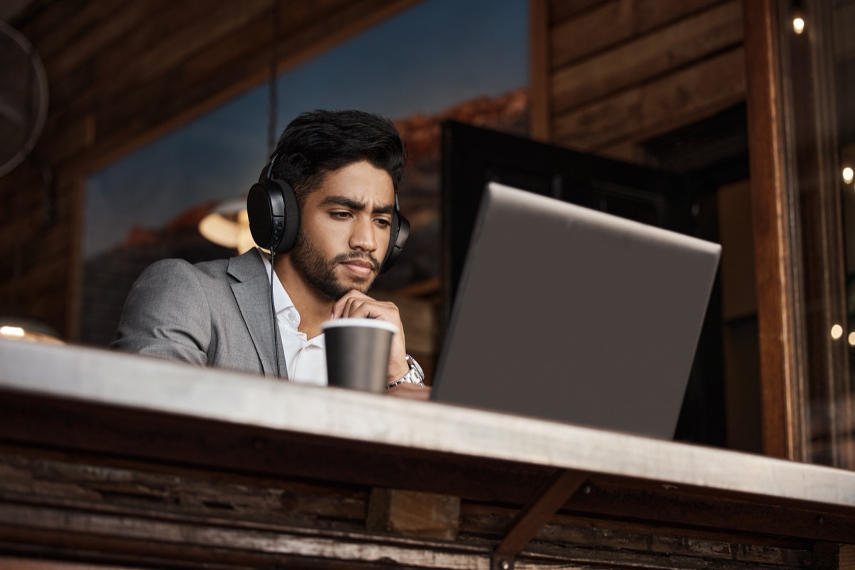 He can work from anywhere. Shot of a young businessman working in a cafe.