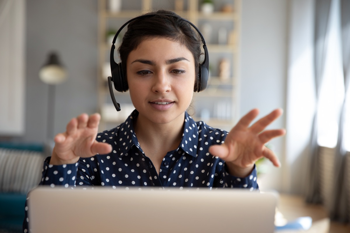 Young woman doing remote tutoring with headset on