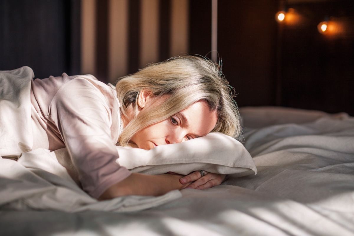 woman sad and sick in bed