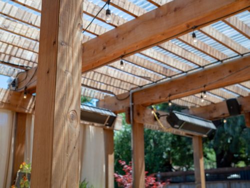 An outdoor restaurant set up with patio and wooden overhang and speakers