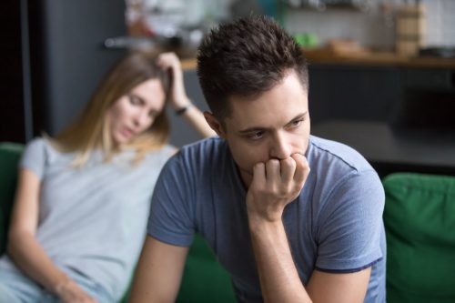 Man and woman sitting on couch looking away from each other