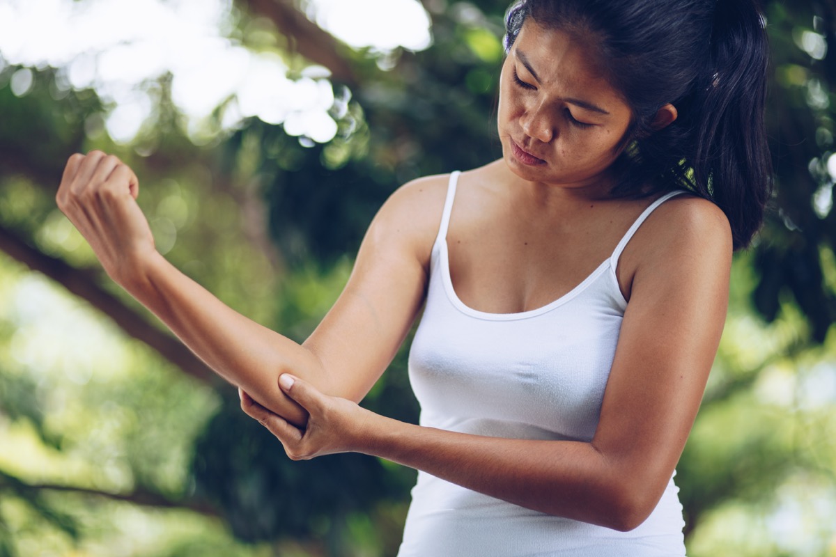 Woman holding her elbow examining pain