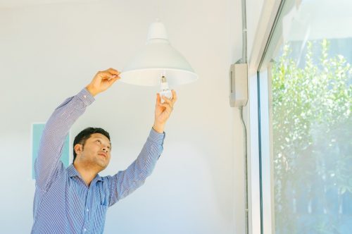 young man fixing light bulb