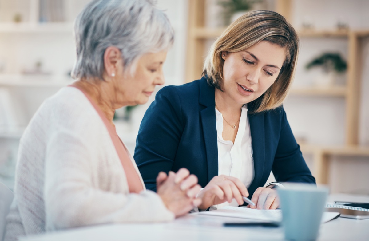 financial advisor looking at paperwork with mature woman