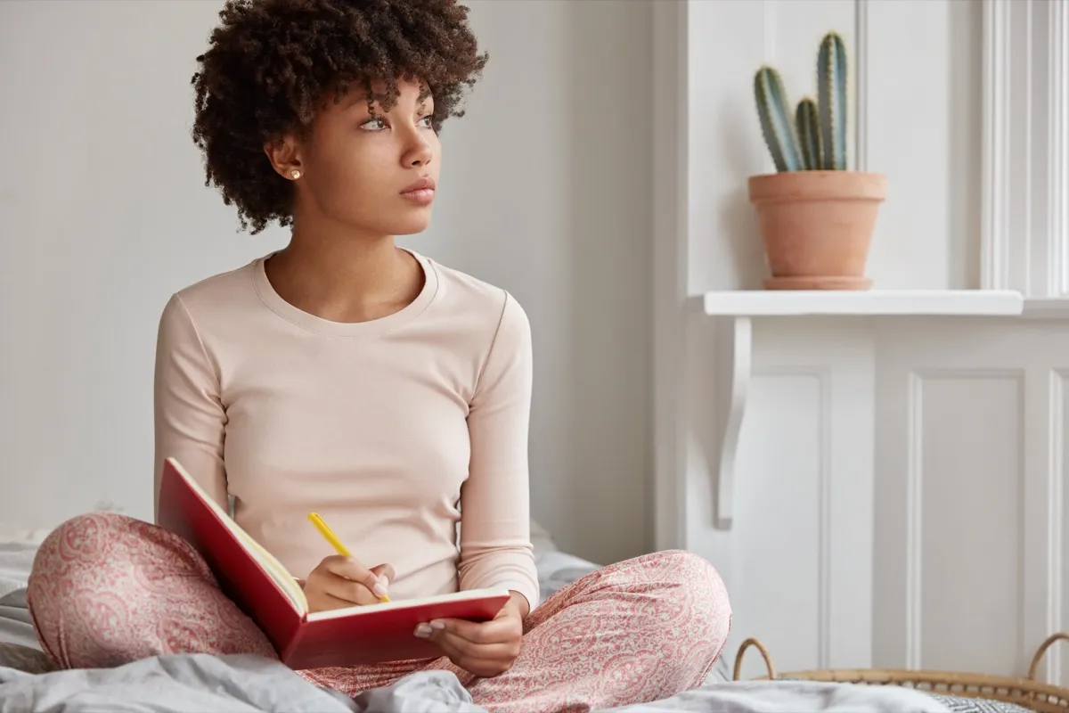 Woman journaling in bed