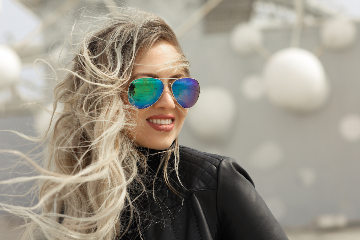 portrait of a young blond woman in aviator sunglasses and a black leather jacket