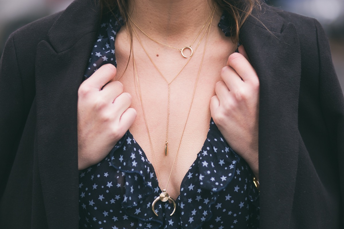 perfect fall outfit accessories. fashion blogger wearing a black elegant coat, a v-neck see through shirt and a beautiful and trendy golden chain necklace