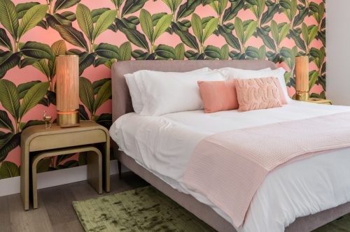 Bedroom with pink and green accent colors and tropical wallpaper theme