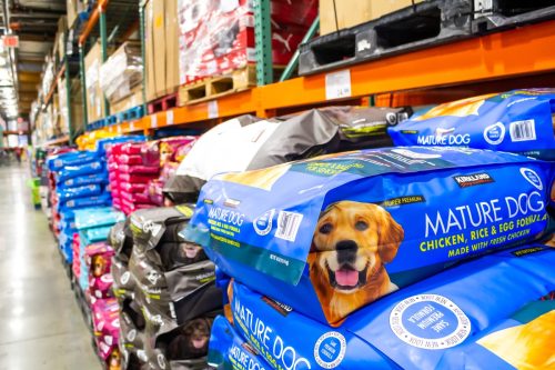 A view of the dog food section at Costco, featuring a package of Kirkland Signature Mature Dog pet food.