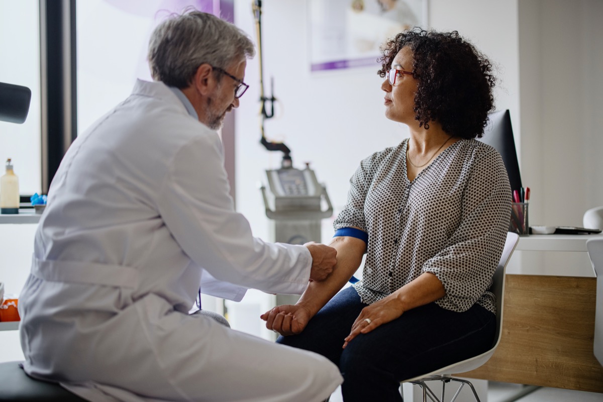 A woman getting her blood pressure taken by a doctor