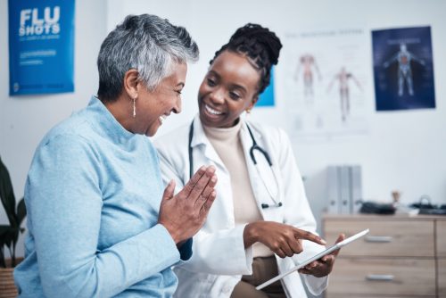 woman, doctor and elderly patient with good news, tablet and results for health, advice and report. Happy african medic, mobile touchscreen or healthcare with smile, tech or support in hospital