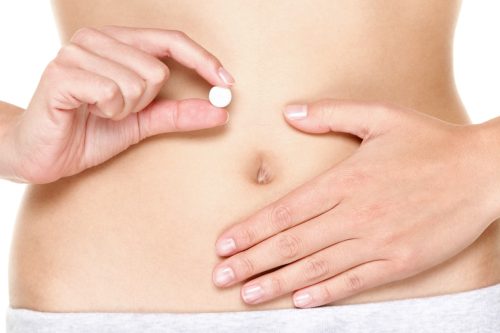 woman holding digestive enzyme pill