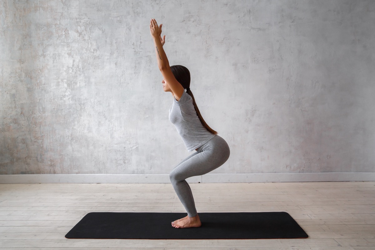 Woman practicing yoga doing chair pose