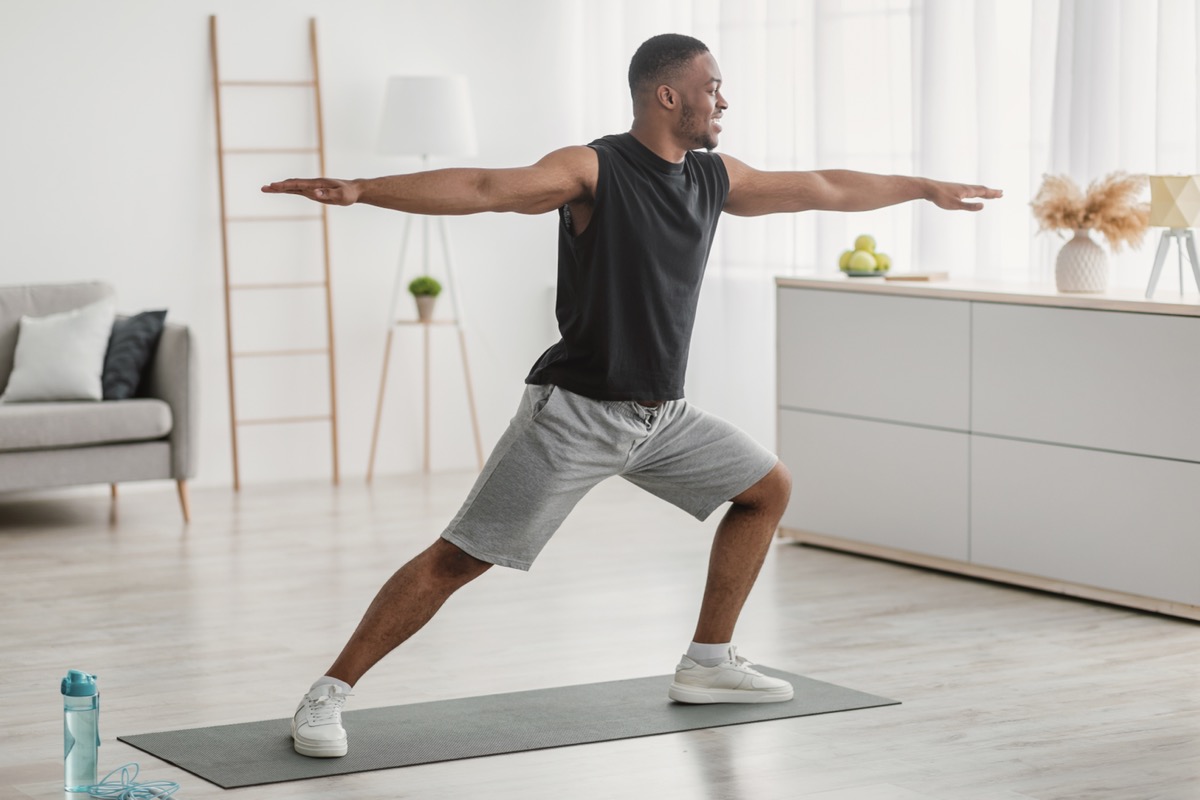 Young man doing yoga in warrior pose