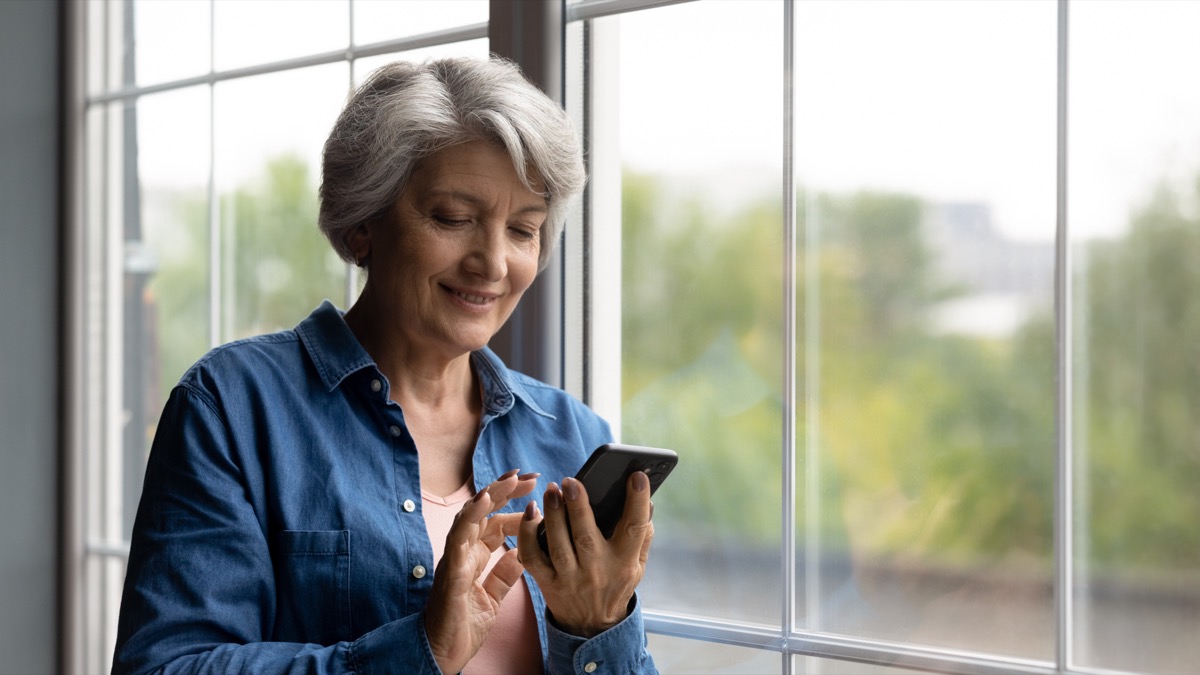 Woman smiling looking at her phone.