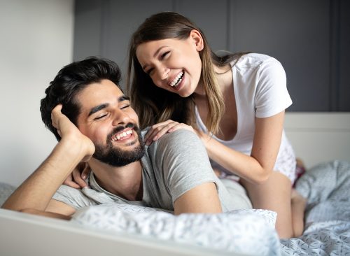 Cheerful young couple making massage at home