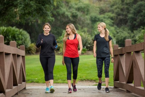 Group of three women in their 30s walking together outdoors