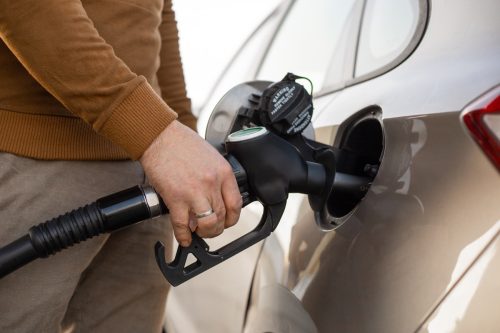 Car refueling on the petrol station. Hand refilling the car with fuel. Close up view. Gasoline, diesel is getting more expensive.