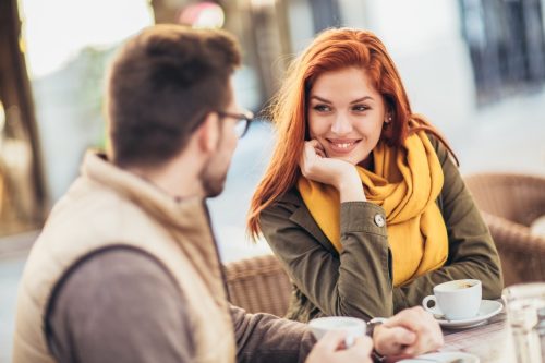 mand and woman chatting at a cafe