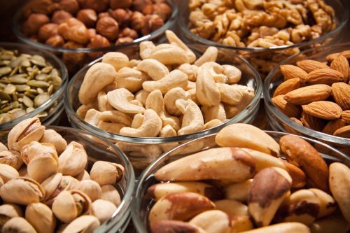 Various snacks,nuts,and dryed fruits in glass dish bowles.