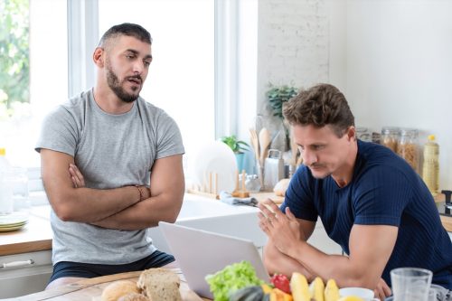 Mature caucasian gay male couple having an argument while having breakfast in the morning at home