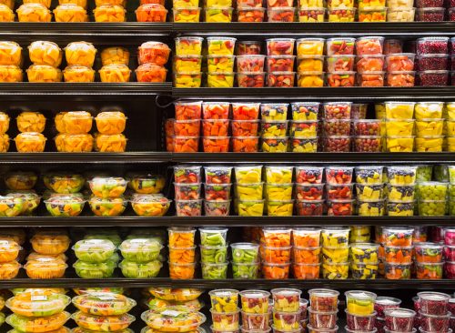 Assortment of cut fruit in containers on display for sale