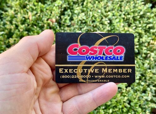 Executive Member Costco membership card, man holding outdoors.