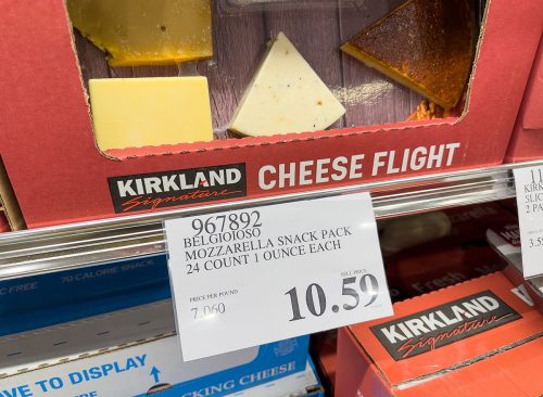 Closeup of a price tag for mozzarella snack pack inside Costco warehouse.