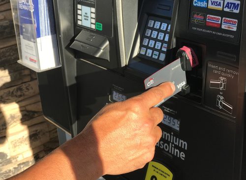 Costco Gas Station, Man swiping credit card on gas station paying for gas with Citi Visa.