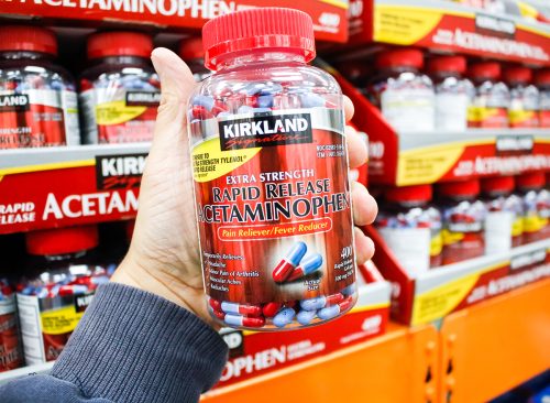 Los Angeles, California, United States - 02-13-2020: A hand holds a bottle of Kirkland Signature extra strength Rapid Release Acetaminophen on display at a local Costco.